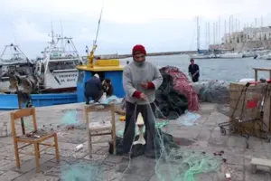 Porticciolo del Canneto a Gallipoli con paranze e reti da pesca, simbolo delle tradizioni marinare.